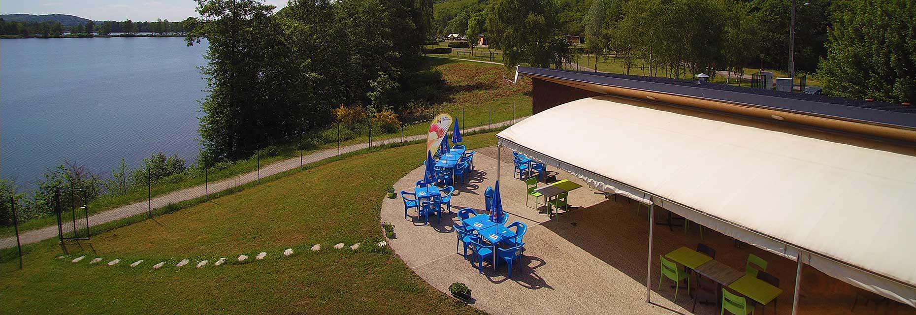 Gesamtansicht des Bar-Restaurants am Wasser Le Titan auf dem Campingplatz Les Ballastières in den Südvogesen