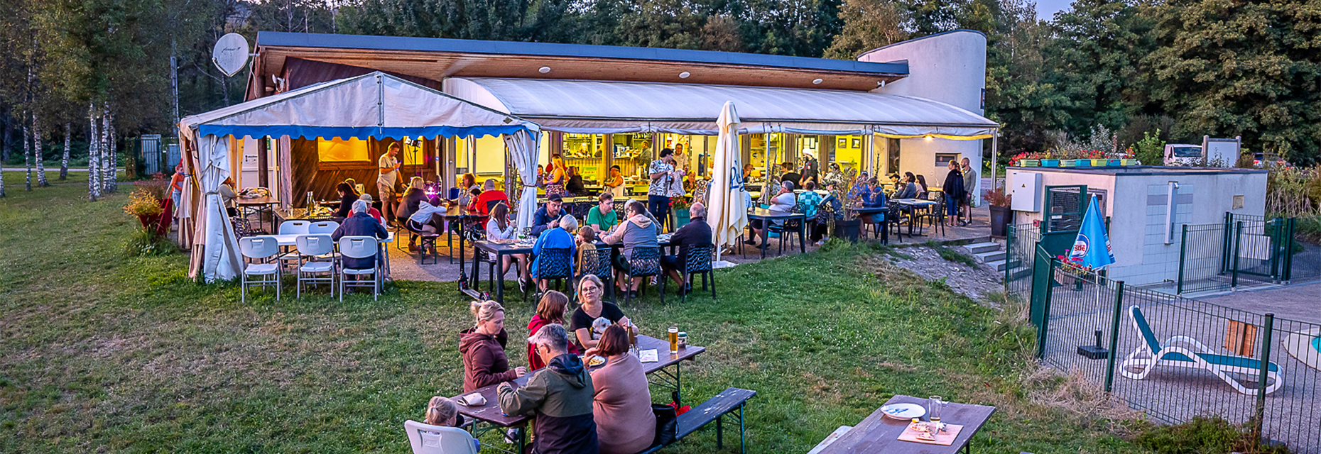 Gesamtansicht des Bar-Restaurants am Wasser Le Titan auf dem Campingplatz Les Ballastières in den Südvogesen