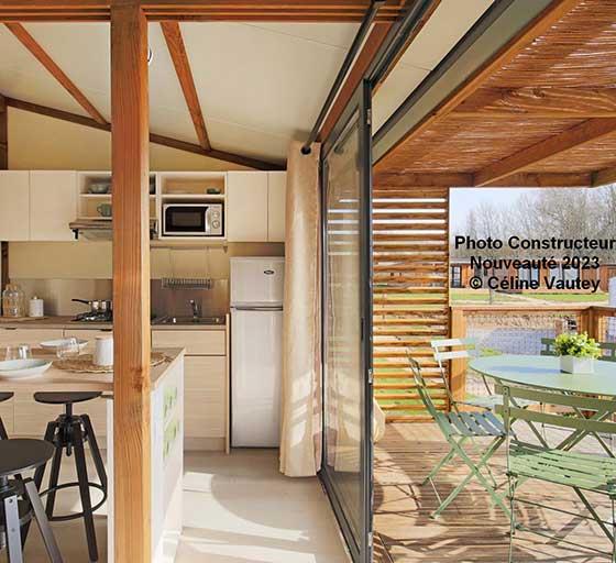 Das Innere des Chalets Cottage 35 m² 3 Zimmer mit Terrasse, ausgestatteter Küche und Wohnzimmer, zu mieten auf dem Campingplatz Les Ballastières