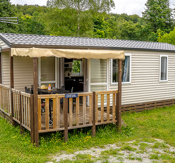 Vue extérieure du mobil-home 3 chambres Classique avec terrasse, en location au camping les Ballastières en Haute-Saône