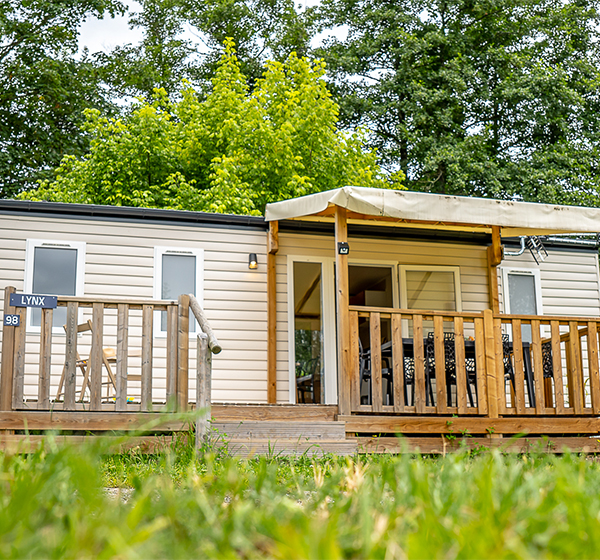 Das Innere des Mobilheims mit 3 Zimmern Premium mit ausgestatteter Küche und Wohnzimmer, zu mieten auf dem Campingplatz Les Ballastières in Haute-Saône