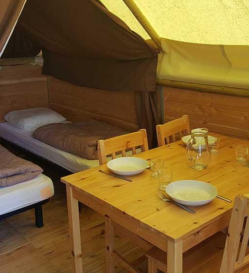 De eetruimte en de kamers van de Canadese tent, een ongewone accommodatie op de camping Ballastières in Bourgondië-Franche-Comté