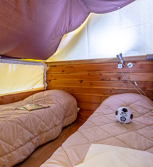 Chambre avec lit superposé de la tente insolite trappeur, location hébergement insolite au camping les Ballastières dans les Vosges du Sud