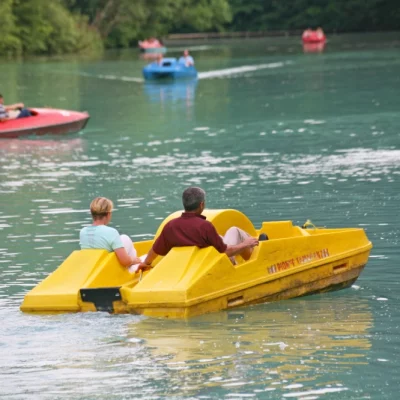 Personnes sur pédalos jaunes sur un lac.