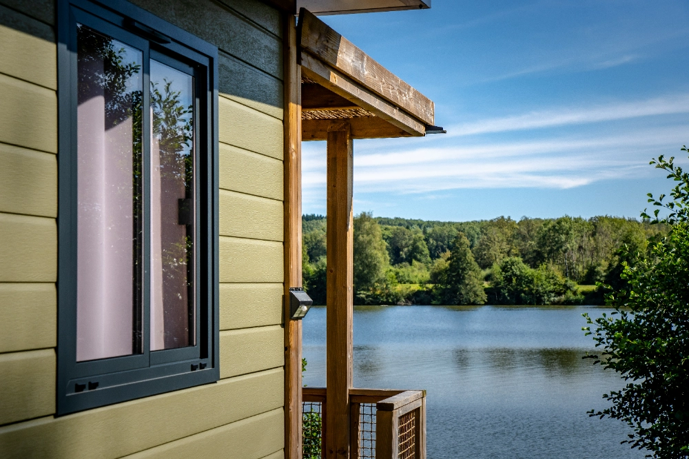 Vue sur lac depuis une terrasse en bois.
