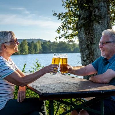 Couple heureux trinque près d'un lac paisible.