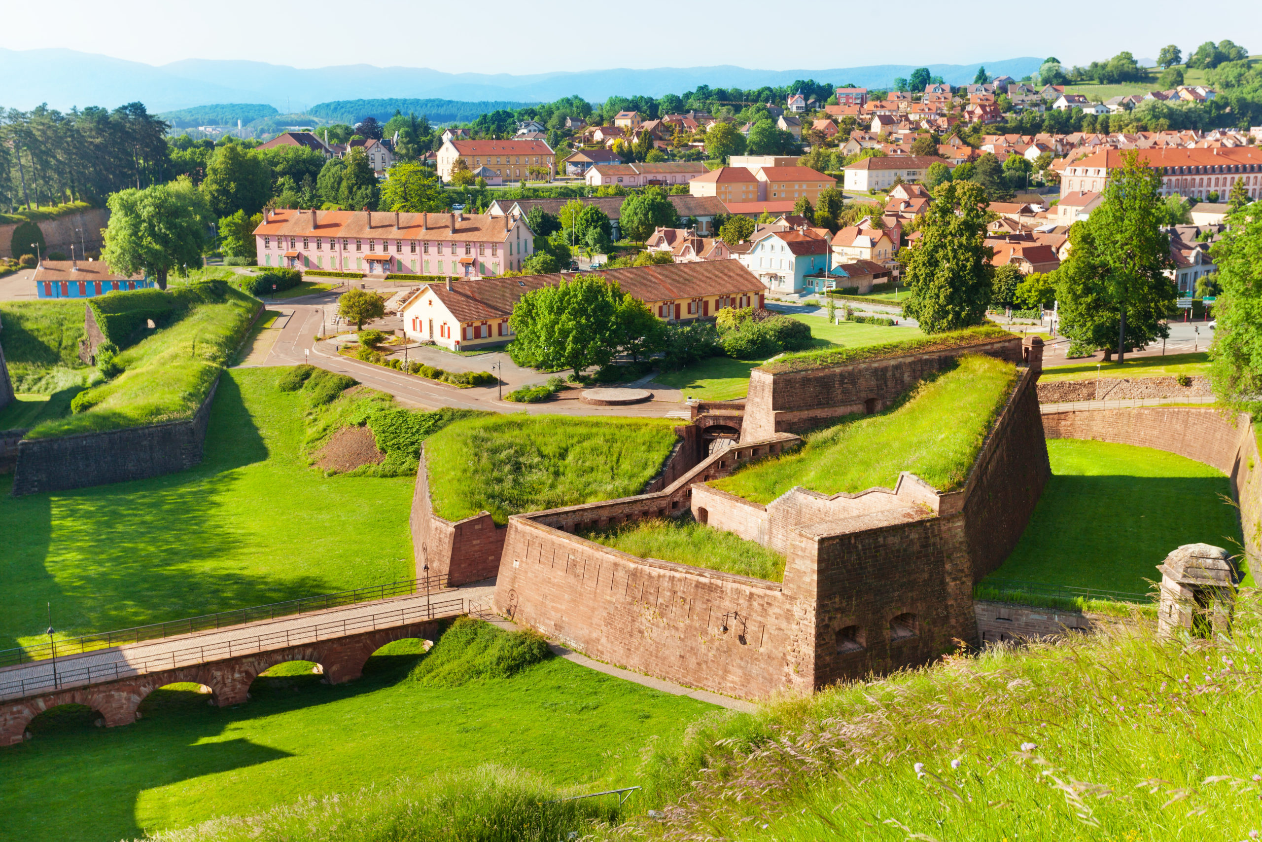 Citadelle de la ville avec maisons historiques verdoyantes.