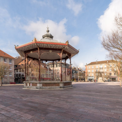 Historic gazebo in European town square, sunny day.