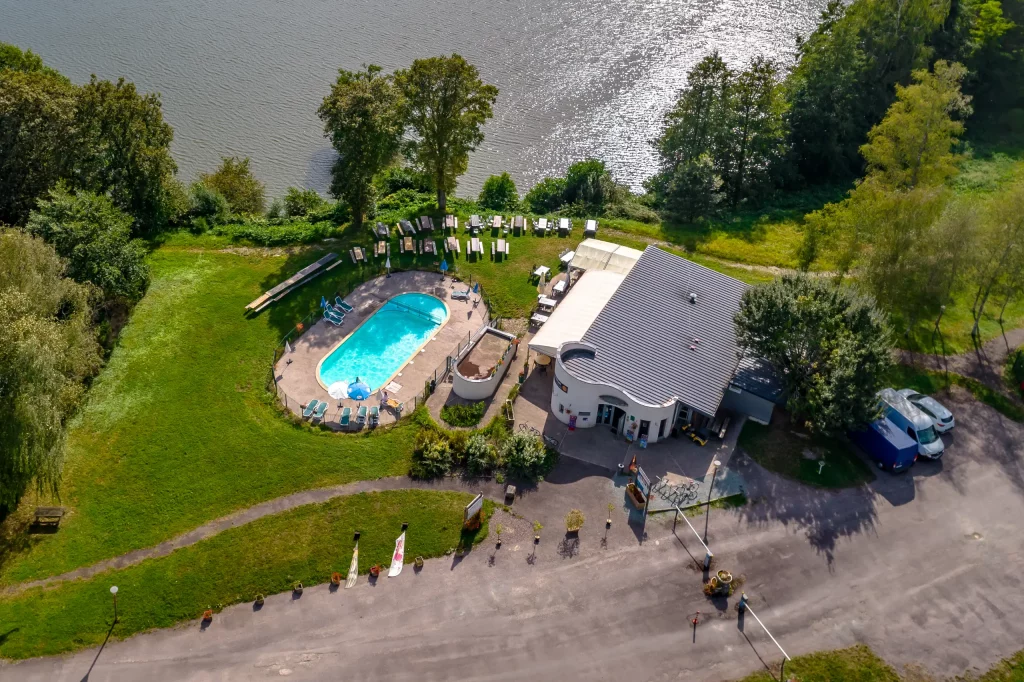 Vue aérienne piscine et bâtiment près d'un lac.