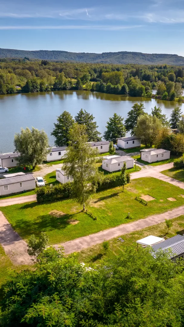 Vue aérienne d'un camping près d'un lac paisible.