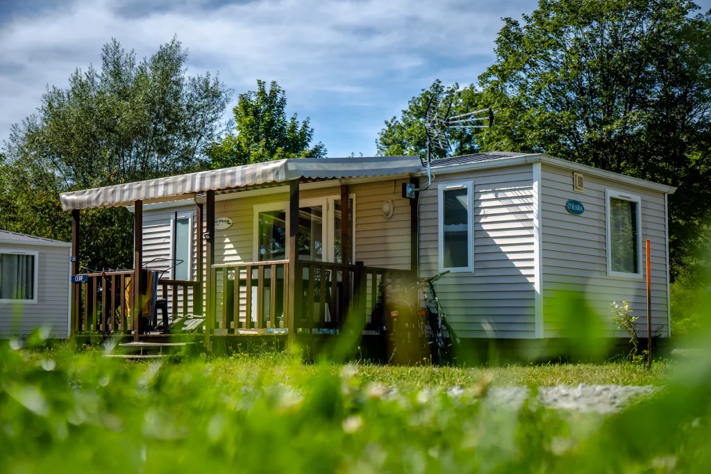 Mobil-home dans la verdure sous le soleil.