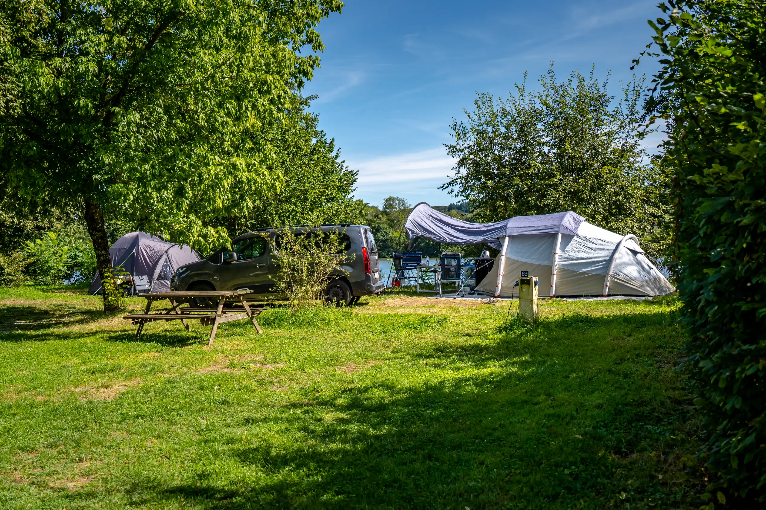 Camping avec tente, voiture, table de pique-nique
