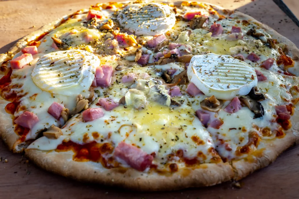 Pizza fromage, jambon, champignons, brie, herbes aromatiques