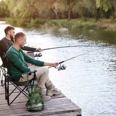 Deux hommes pêchant au bord d'une rivière.