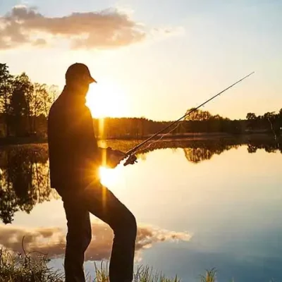 Pêcheur au coucher du soleil près du lac.