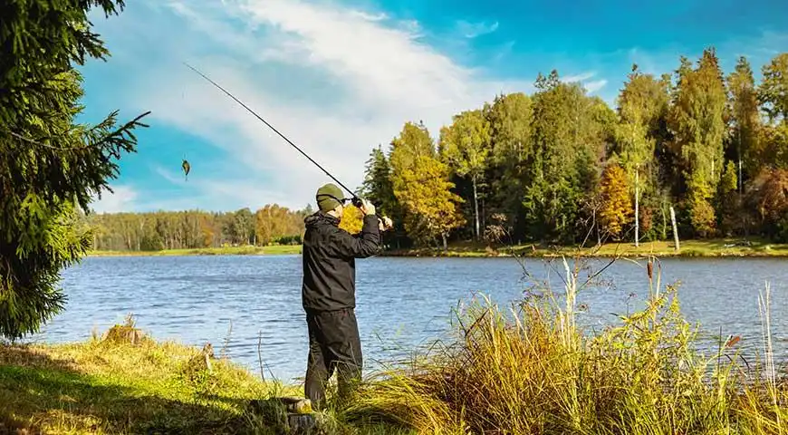 Homme pêchant au bord d'un lac pittoresque