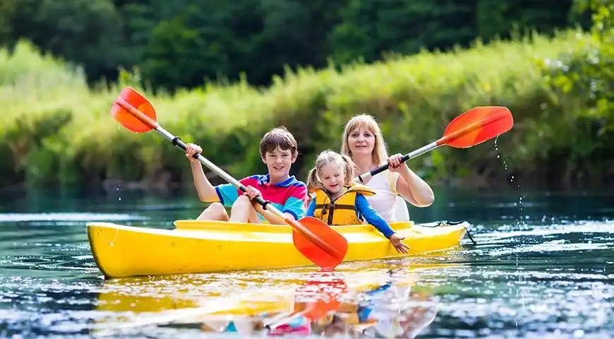 Famille pagayant en kayak sur la rivière