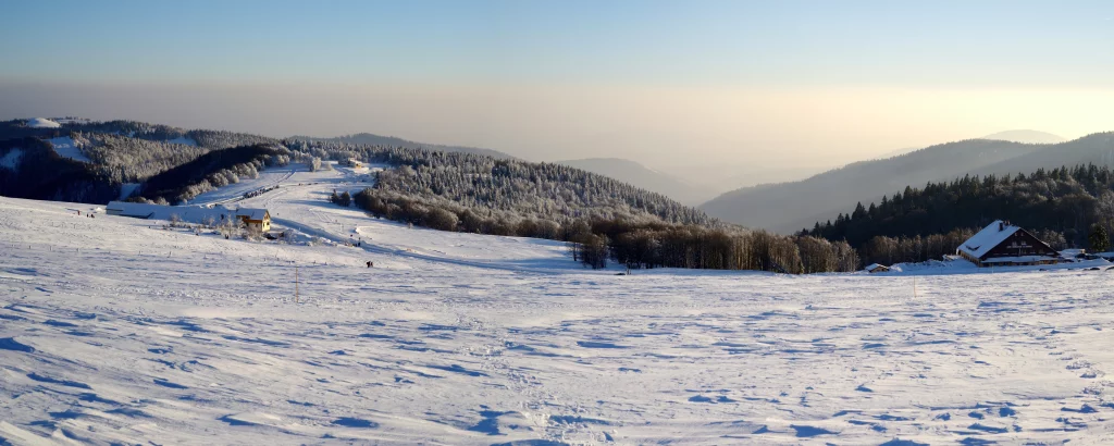 Paysage enneigé avec montagnes et cabanes.