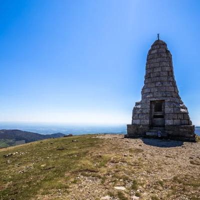 Monument en pierre sur sommet montagne, ciel bleu