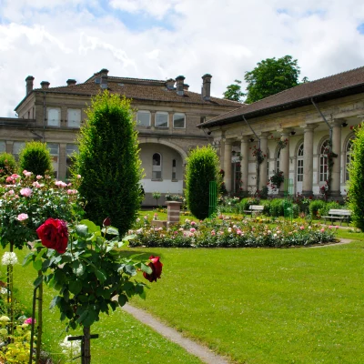 Jardin fleuri devant bâtiment historique.