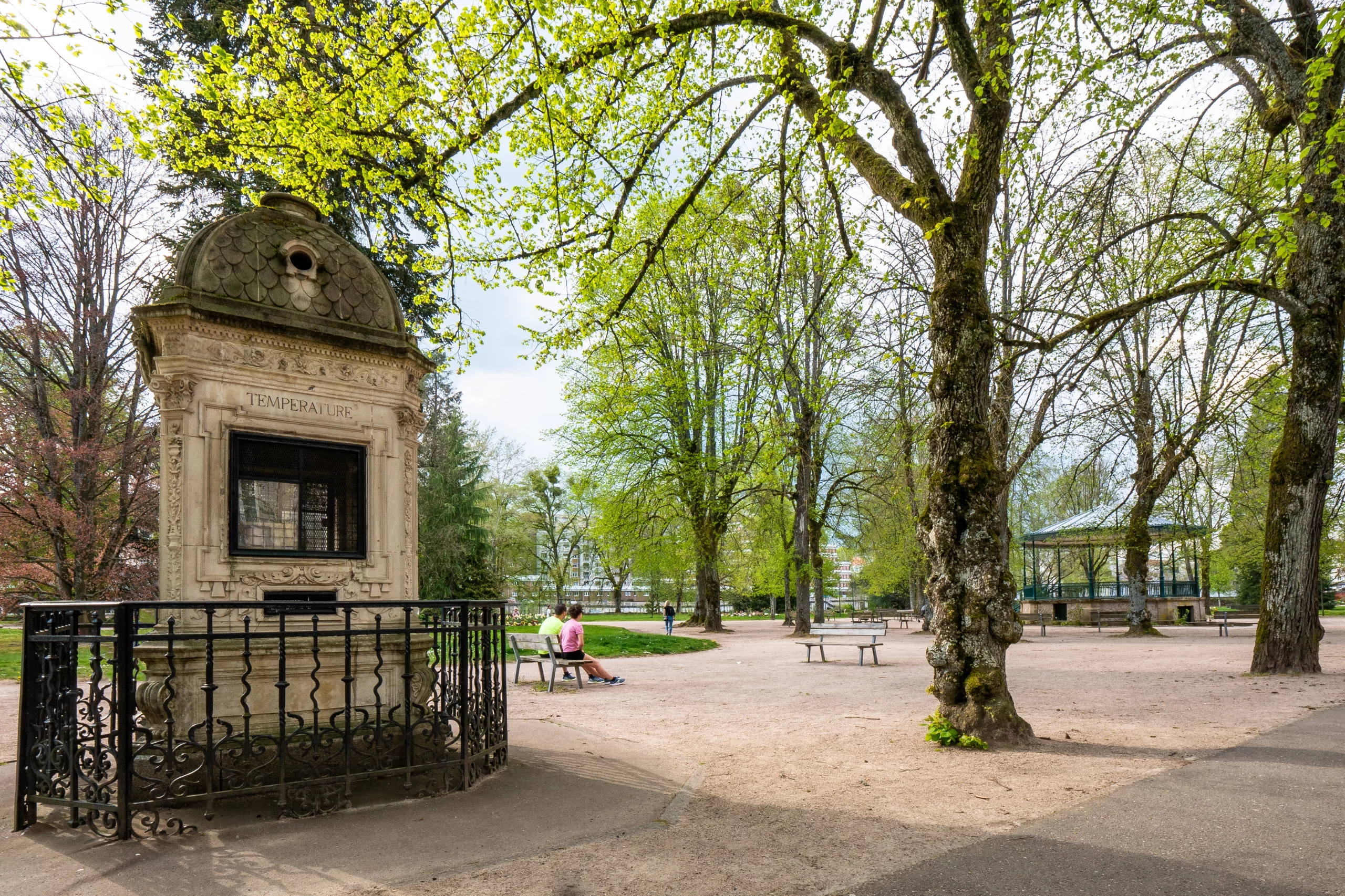 Jardin public avec monument ancien et bancs