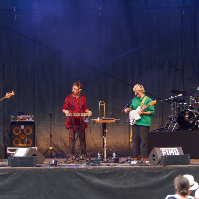 Groupe de musique en concert sur scène extérieure.