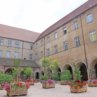Cour intérieure historique avec fleurs colorées.
