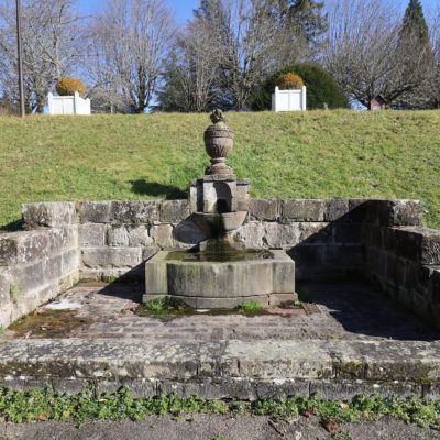 Fontaine en pierre avec vase décoratif.