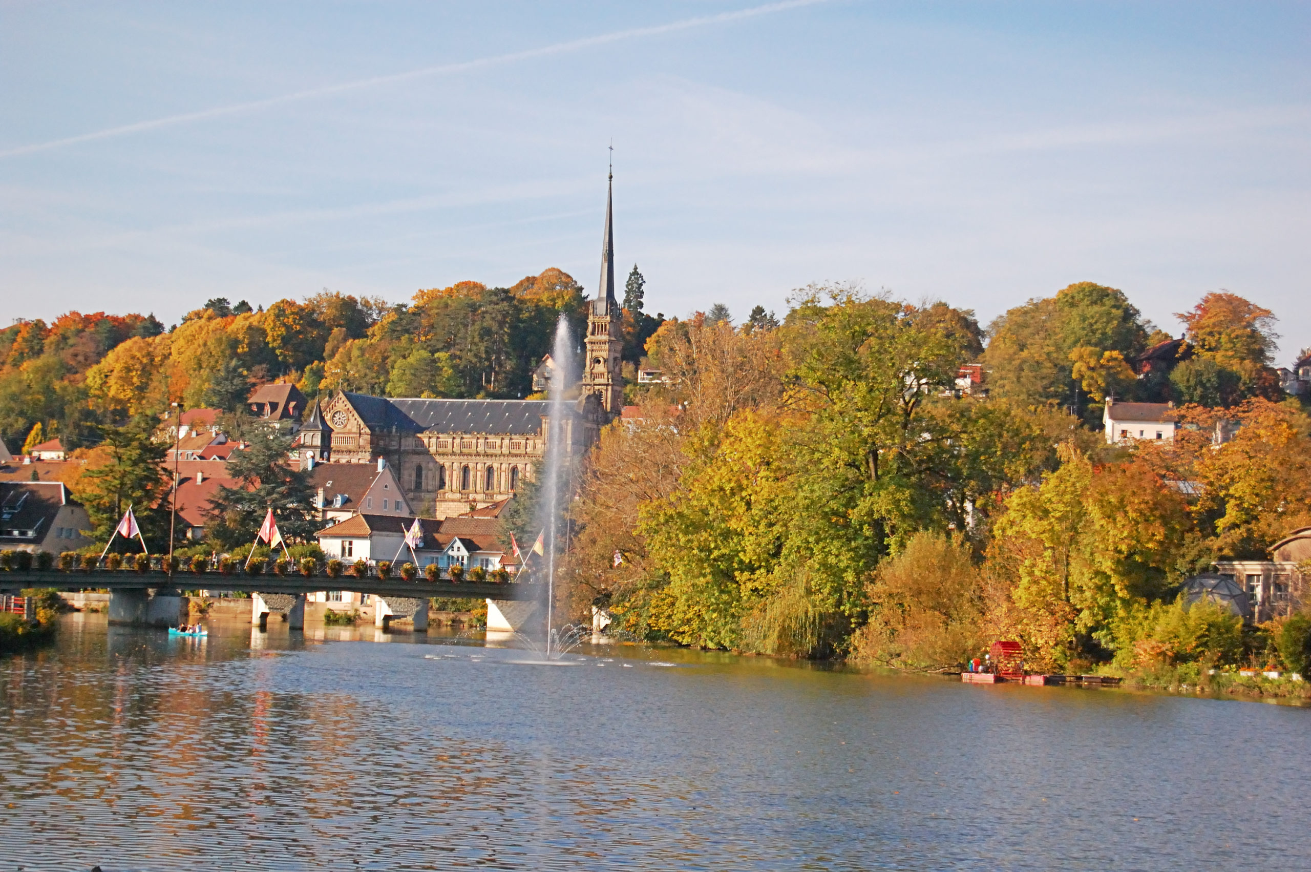 Abbaye de Maredsous avec fontaine sur rivière.