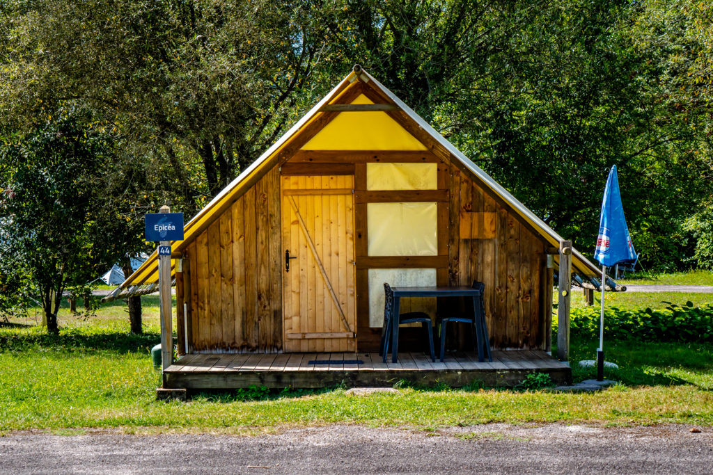 Cabane en bois avec terrasse dans la forêt.