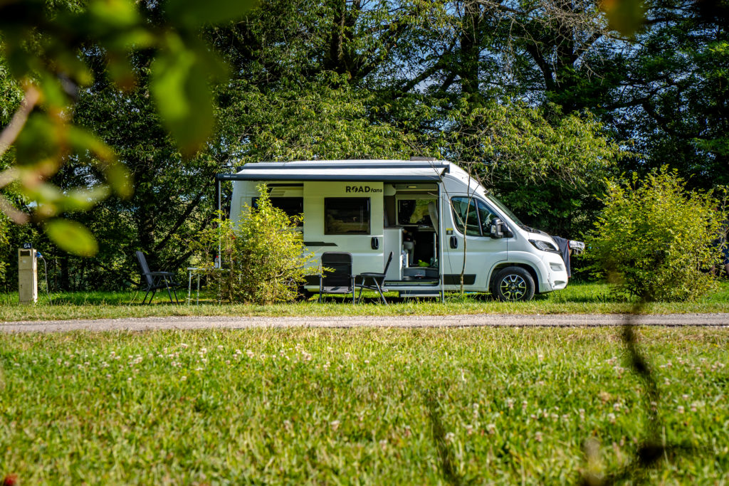 Camping-car stationné dans un cadre verdoyant.
