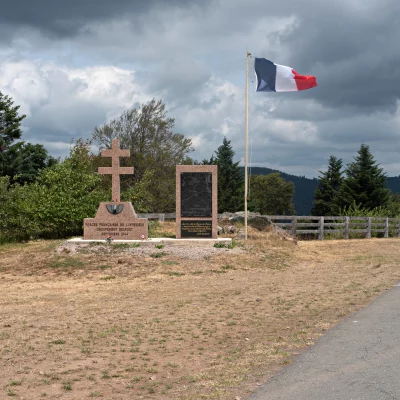 Mémorial avec drapeau français sur une colline.