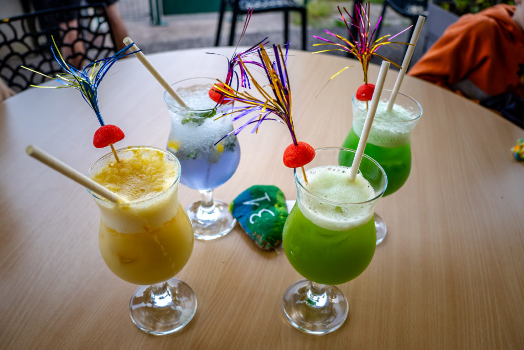 Cocktails colorés sur table en bois.