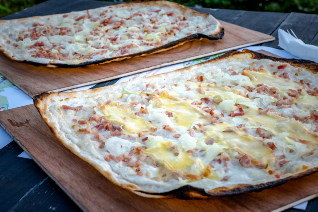 Flammekueche traditionnelle sur planche de bois.