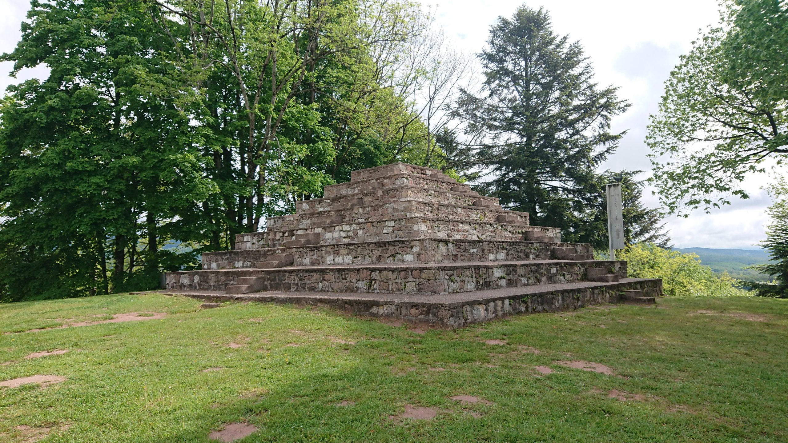Petit temple de pierre entouré d'arbres verdoyants.