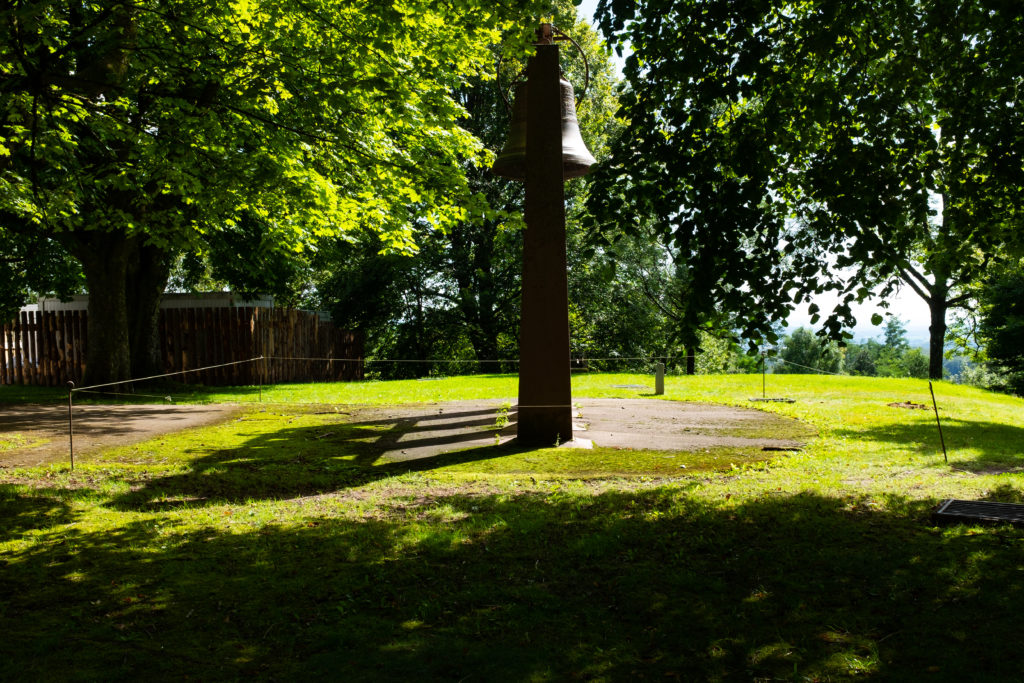 Cloche sous les arbres, parc ensoleillé.