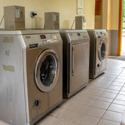 Salle de lavage avec trois machines à laver.