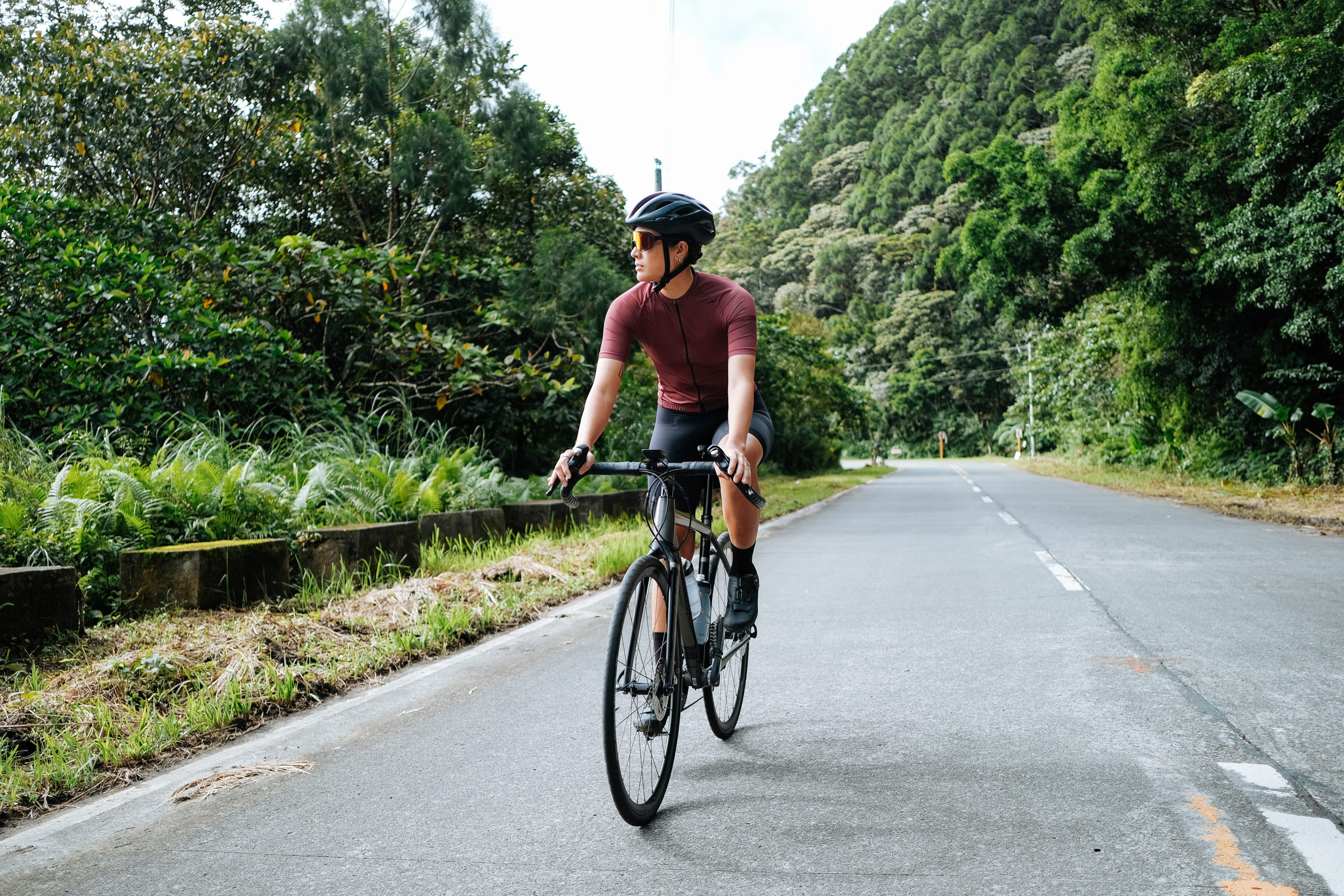 Cycliste sur route entourée de verdure.