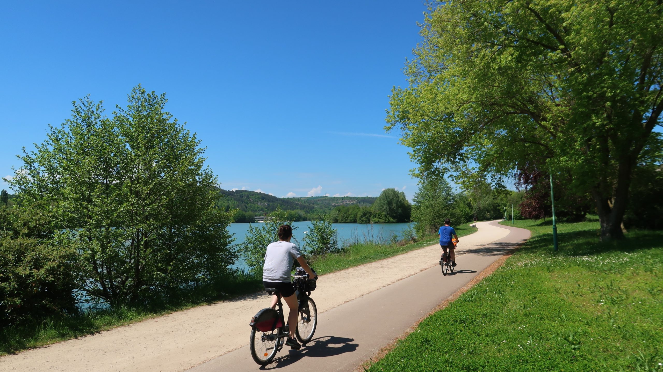 Cyclistes sur une piste le long d'un lac.