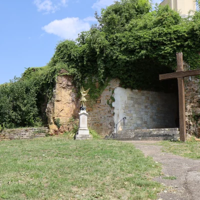 Entrée d'une grotte avec croix en bois.