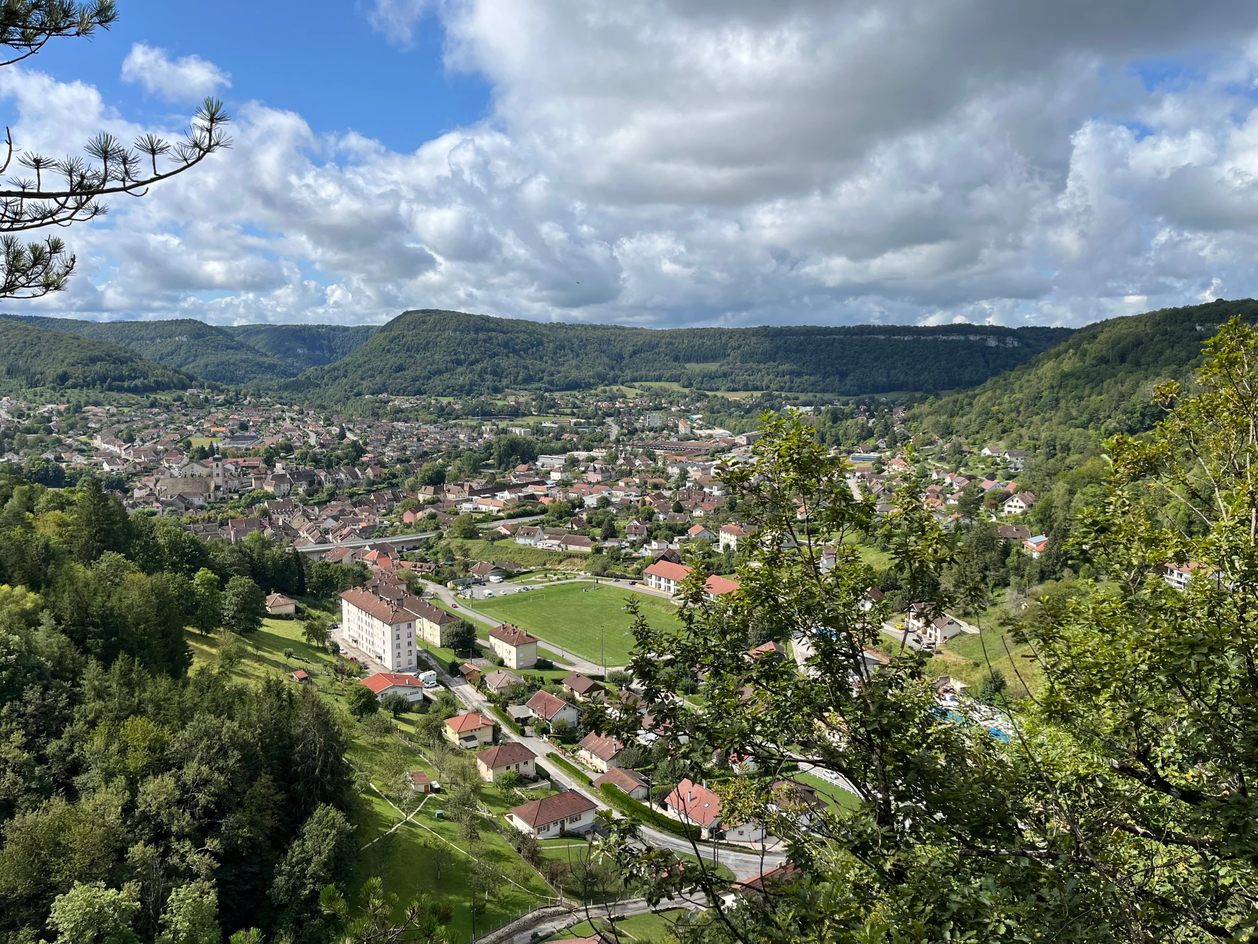 Vue panoramique sur une ville entourée de collines.