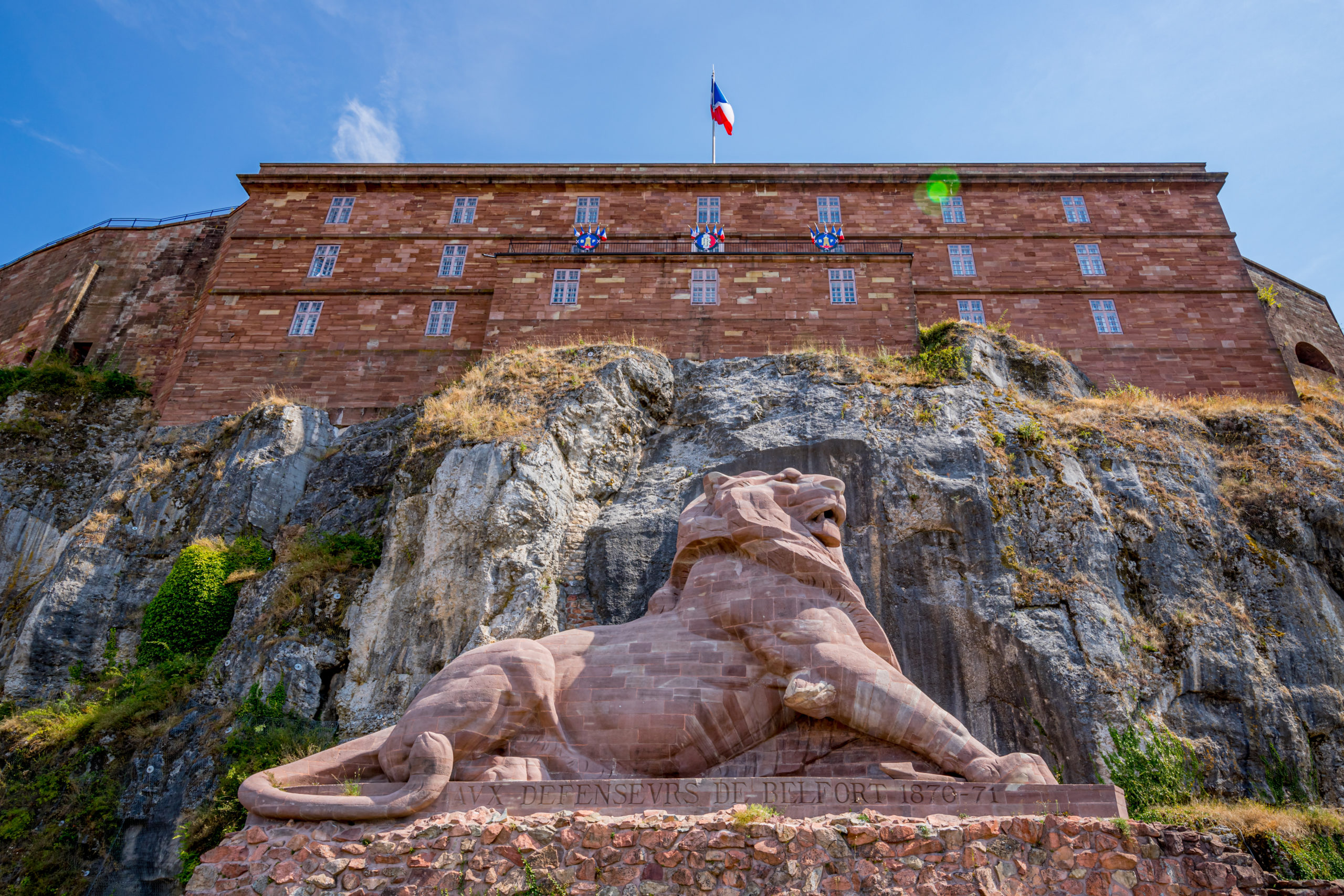 Statue du Lion de Belfort devant forteresse.